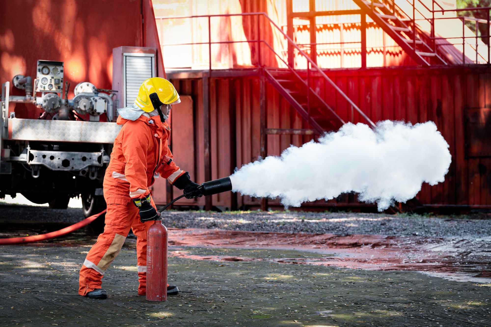 Fireman wearing firefighting suite using fire extinguisher fighting fire equipment and accessories i